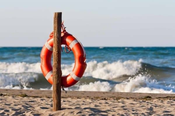 Rettungsreifen aufgehangen an einem Holzpfahl am Meeresstrand